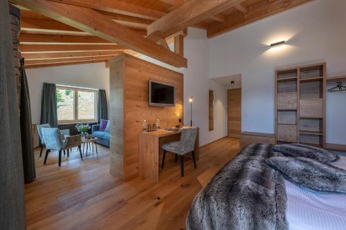 a bedroom with a large bed and a dining room at Berghotel Tgantieni in Lenzerheide