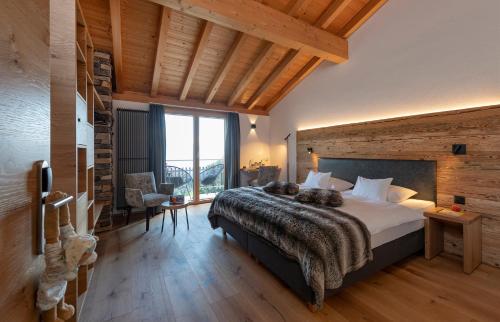 a bedroom with a large bed in a room with wooden ceilings at Berghotel Tgantieni in Lenzerheide
