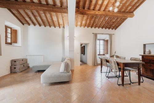 uma sala de estar com uma mesa e um sofá em Palazzo Massaini - La Pieve em Pienza