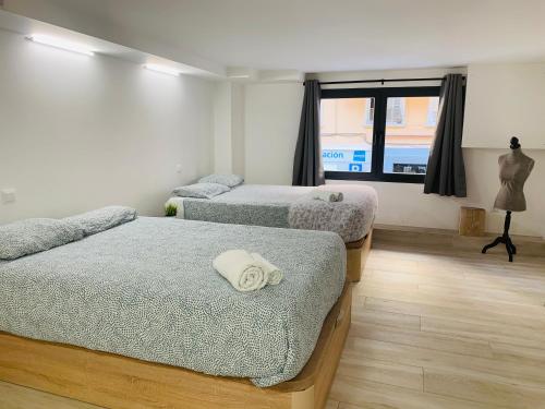 Zimmer mit 3 Betten und einem Fenster in der Unterkunft NUEVOS DUPLEX PRINCIPE VERGARA in Madrid