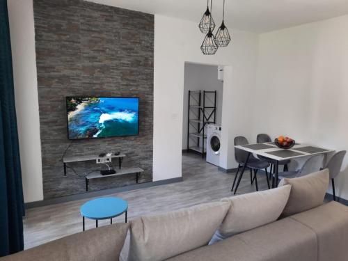 a living room with a couch and a tv on a brick wall at Seaside Village in Kamenari
