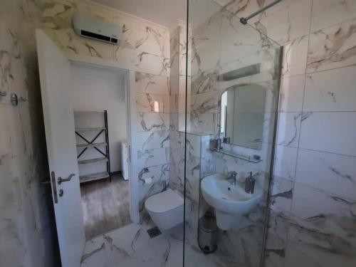 a bathroom with a sink and a toilet and a shower at Seaside Village in Kamenari
