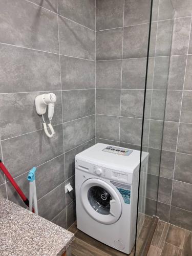 a washing machine in a bathroom with a phone at Бутикови Студиа БРИТА in Kranevo