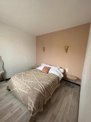 une chambre avec un lit et un parquet dans l'établissement magnifique appartement en bord de mer, à Valras-Plage