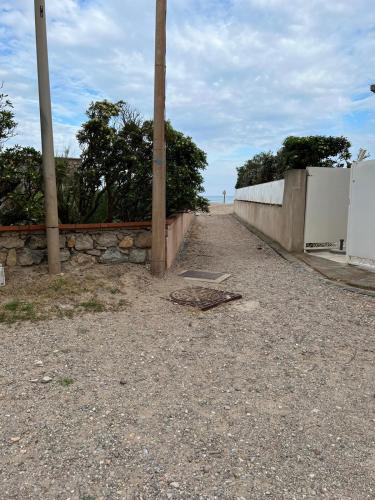 un chemin de terre avec un mur en pierre et une clôture dans l'établissement magnifique appartement en bord de mer, à Valras-Plage