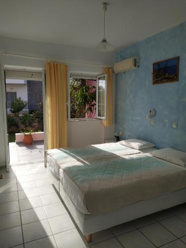 una camera da letto con un letto grande e una finestra di Livadi Apartments a Plakiás