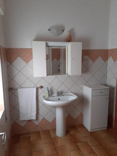 een badkamer met een wastafel en een spiegel bij Ginepro in San Vito
