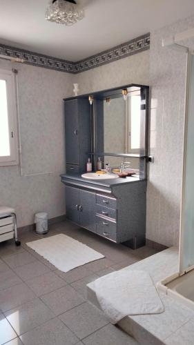 y baño con lavabo y espejo. en Chambre à louer chez l'habitant, en Payré