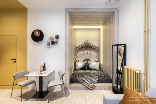 um quarto com uma cama, uma mesa e cadeiras em White Boat Studio Apartment GOLD em Budapeste