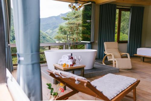uma casa de banho com banheira e vista para uma montanha em Hotel Chateau Iveri em Varjanisi