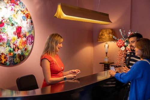 um grupo de pessoas em pé em torno de uma mesa em uma sala em Naâd Hotel Sarlat Centre Ville em Sarlat-la-Canéda