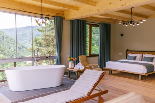 a bedroom with a tub and a bed and a view at Hotel Chateau Iveri in Varjanisi
