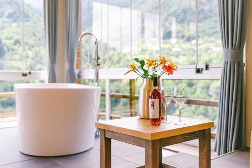 een tafel met een fles wijn en een vaas met bloemen bij Hotel Chateau Iveri in Varjanisi