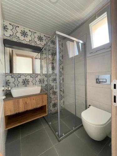 uma casa de banho com um chuveiro, um WC e um lavatório. em Adil Pansiyon em Cesme