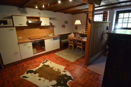 a kitchen with white cabinets and a table in it at Hoglhaus & Malerwinkel in Mittenwald