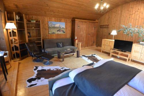 a living room with a bed and a couch at Hoglhaus & Malerwinkel in Mittenwald