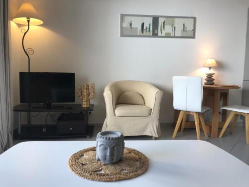 Cette chambre comprend un lit, une chaise et une télévision. dans l'établissement Studio w/ balcony ideal for congress & holidays, à Cannes