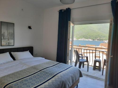 sypialnia z łóżkiem i balkonem z widokiem w obiekcie Seaside Village w mieście Kamenari