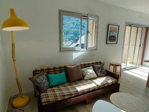 een woonkamer met een bank en een raam bij Studio Cauterets, 1 pièce, 4 personnes - FR-1-234-242 in Cauterets