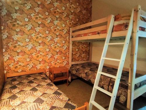 - une chambre avec 2 lits superposés et un mur orné de fleurs dans l'établissement Appartement Duplex Calme 6 pers, Terrasse, Parking Privé, 500m du Centre - FR-1-234-252, à Cauterets