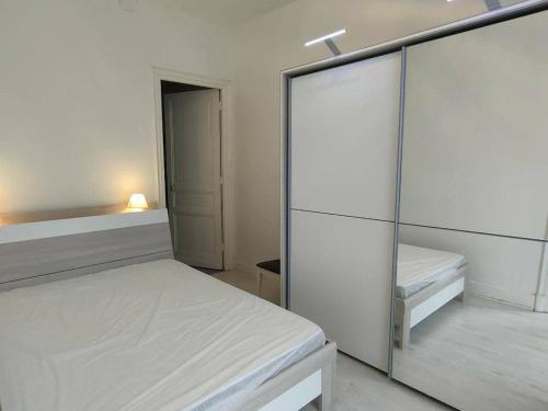 une chambre blanche avec un lit et un placard dans l'établissement Appartement Centre Cauterets - 2 Pièces, 4/6 Pers, Parking, 45 m² - FR-1-234-153, à Cauterets