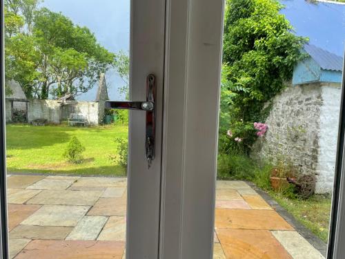an open door with a view of a yard at Kerry Country House in Kilteean