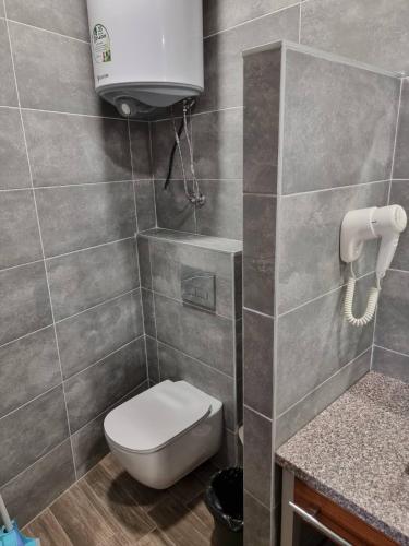 a bathroom with a toilet and a water tank at Бутикови Студиа БРИТА in Kranevo