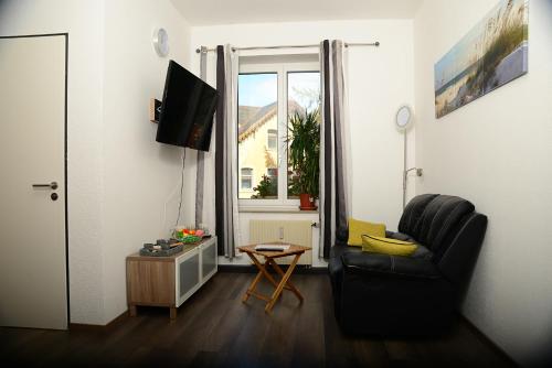 a living room with a chair and a window at Ferienanlage Markus Nitsch in Bärenstein