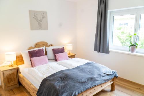una camera da letto con un grande letto con cuscini rosa di Ferienwohnung Magdalena - Fritz Apartments a Innsbruck