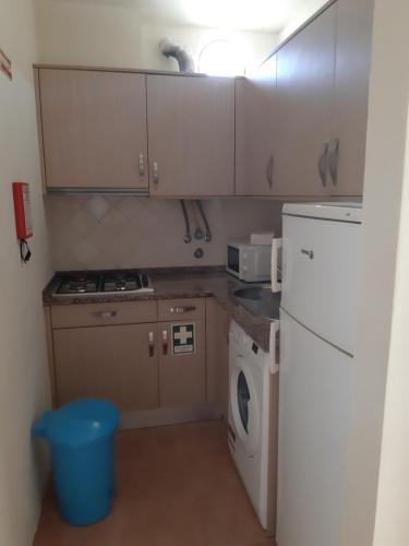 Il comprend une petite cuisine équipée d'un réfrigérateur blanc et d'un lave-vaisselle. dans l'établissement Studio com vista mar, à Carvoeiro