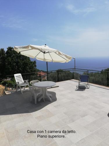 a patio with a table and an umbrella at Fascino del Cilento in Caprioli