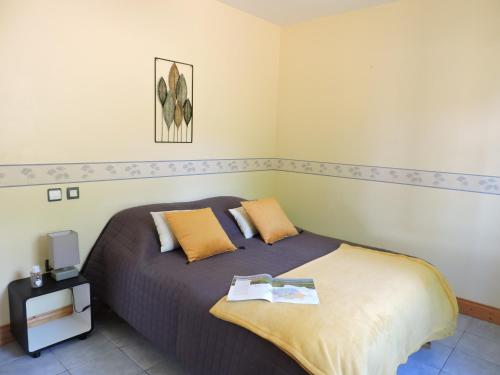 a bedroom with a large bed with yellow pillows at Chalet Mélèze - Les Chalets de Barruérot - Spa jacuzzi privatif - Piscine en été in Peyrusse-Grande