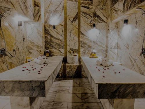 uma casa de banho com duas mesas com pétalas de rosa vermelhas em Stars Hotel & Spa em Marrakech