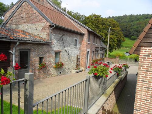 une terrasse en bois devant une maison ornée de fleurs dans l'établissement Schophemmerhoeve, à Fourons