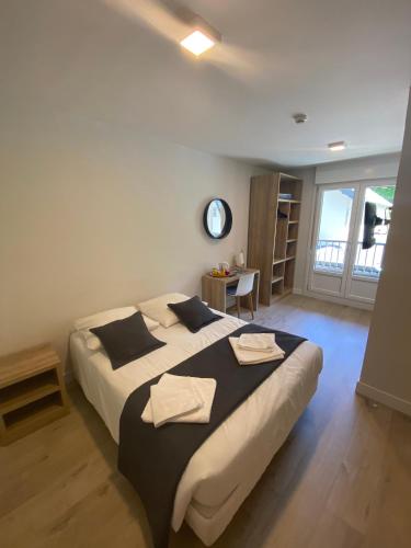 a bedroom with a large bed with towels on it at Hotel Le Chalet in Sainte-Marie-de-Campan
