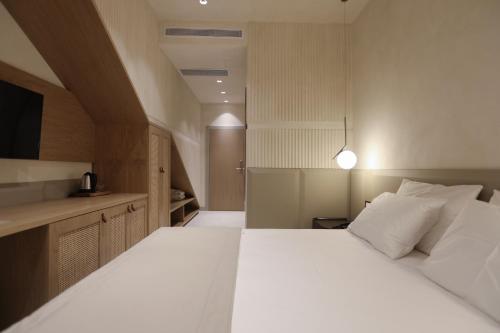 a bedroom with a large white bed and a kitchen at Elite Bay Hotel Lalez Durres in Lalëz
