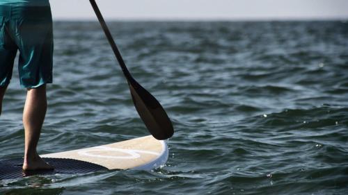 a person standing on a paddle board in the water at Stella d'Aurora waterview in Belmonte Calabro