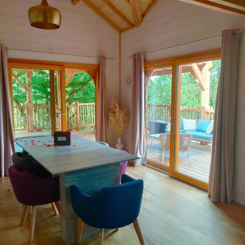 Cette chambre comprend une table, des chaises et une terrasse. dans l'établissement Le château des fées, à Illoud