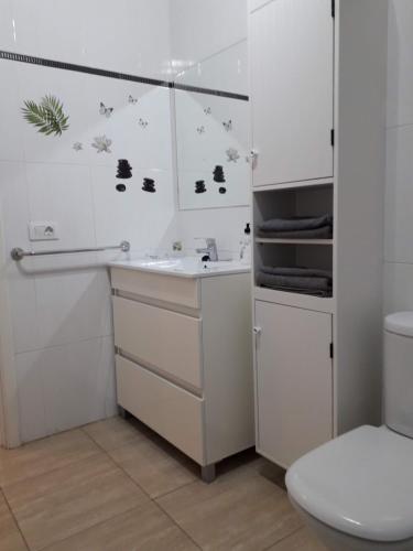 a white bathroom with a sink and a toilet at Departamento Joelle in Puerto del Carmen