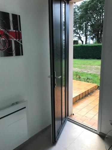 a sliding glass door in a room with a patio at Studio indépendant 35M2, avec grand jardin, gare 5 min, parkings, wifi THD, prox plage in Vannes