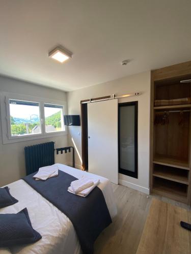a bedroom with a bed with two towels on it at Hotel Le Chalet in Sainte-Marie-de-Campan