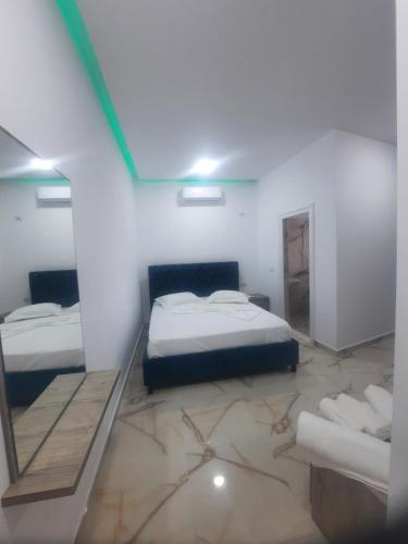 a room with two beds and a mirror at HOTEL MEGNIAR in Lushnjë