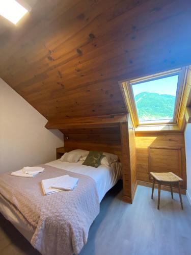 a bedroom with a bed with a large window at Hotel Le Chalet in Sainte-Marie-de-Campan