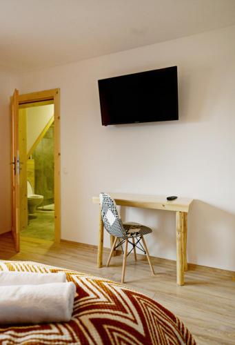 a room with a desk and a television on a wall at Dom Wczasowy Tatrzański in Szaflary