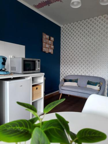 - un salon avec un canapé et un four micro-ondes dans l'établissement Le soleil Dunkerquois, à Dunkerque