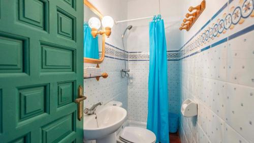 łazienka z toaletą i zielonymi drzwiami w obiekcie Casa Maracuyá Nerja by Ruralidays w mieście Nerja