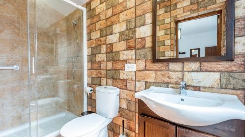 a bathroom with a toilet and a sink and a shower at Casa Rural Sierra de las Nieves Yunquera by Ruralidays in Yunquera