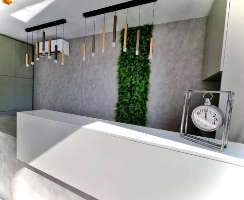 a white counter with a clock on a wall at Hotel Ana Eforie in Eforie Nord