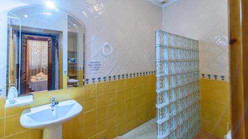 un bagno con lavandino e specchio di El Rincón del Comendador Tocina by Ruralidays a Los Rosales