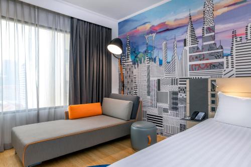 a hotel room with a bed and a couch and a window at Novotel Bangkok on Siam Square in Bangkok